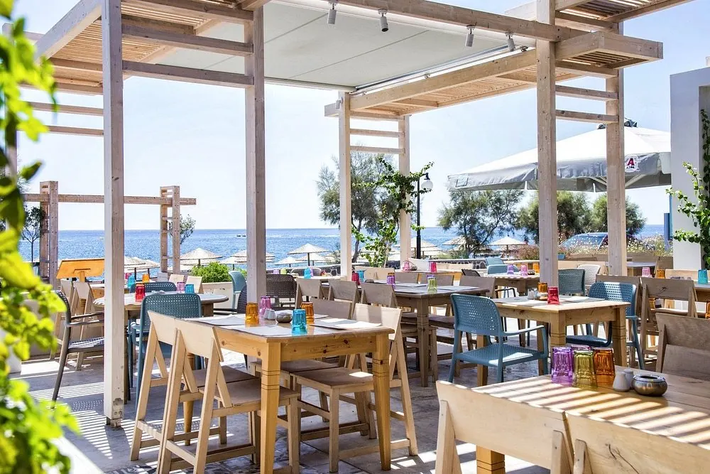 Υπαίθριος χώρος του εστιατορίου κάτω από ξύλινες πέργκολες